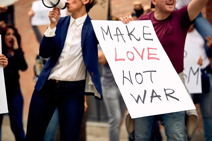 A protestor holding a sign that says 'Stop War' during a peace demonstration.